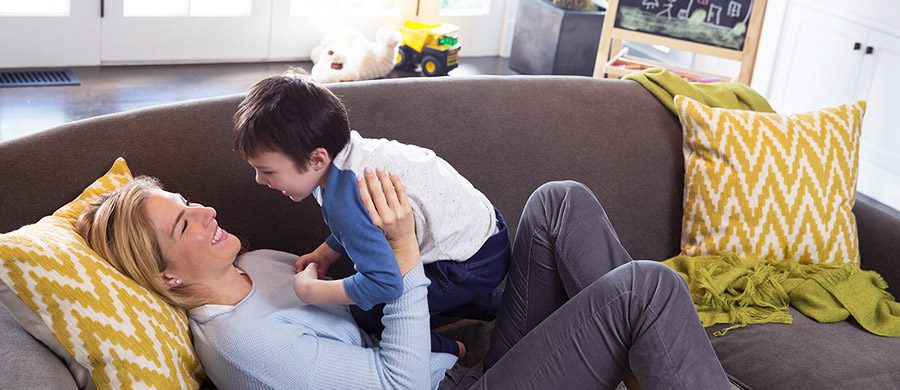 A mother playing with her son on the sofa